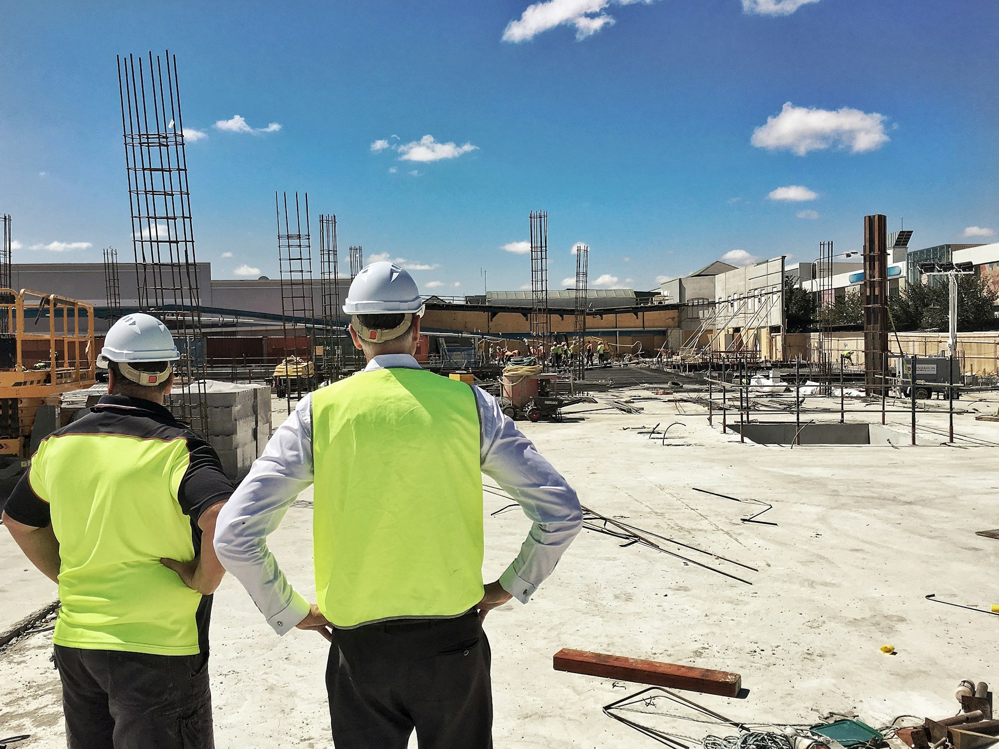 Supervising a construction site wearing safety vests and hard hats